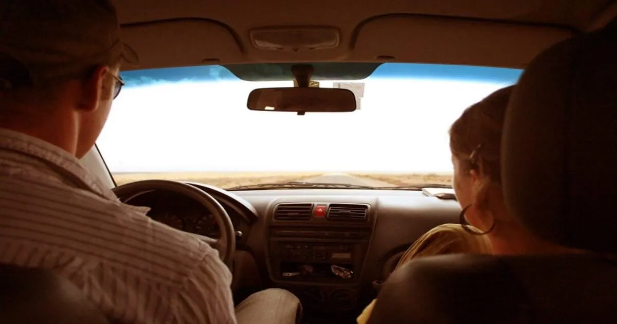 Person booking car rental online on laptop with credit card