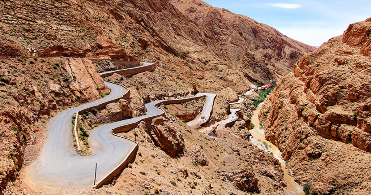 Modern SUV on Morocco mountain road, Atlas landscape in background, visible road signage, good road condition, blue sky 