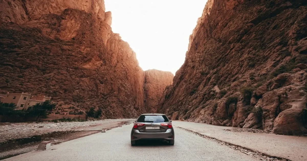 Busy street scene in Moroccan city with cars, motorcycles and pedestrians
