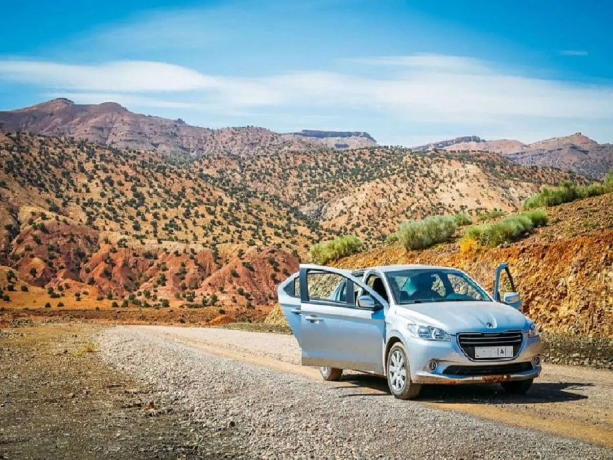 Scenic mountain road winding through Morocco's Atlas Mountains with snow-capped peaks